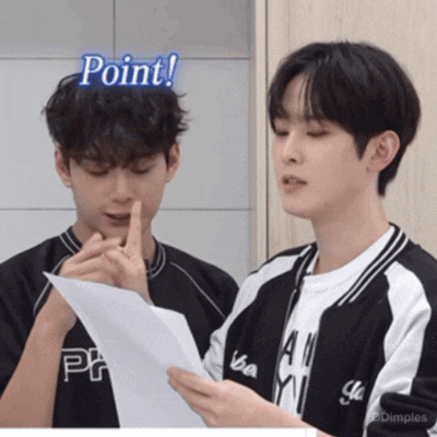 two young men are looking at a piece of paper and one of them has the word point on his head