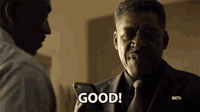 a man in a suit and tie says good