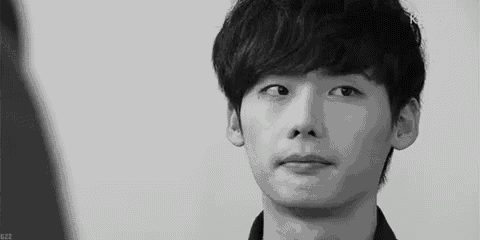 a black and white photo of a young man making a face .