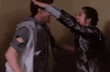 a man and woman are giving each other high fives