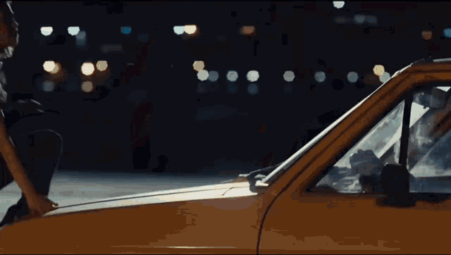 a person is sitting on the hood of a car