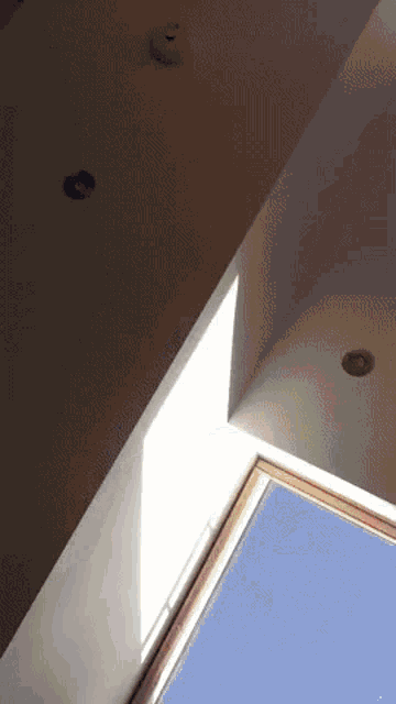 a ceiling with a smoke detector on it and a window
