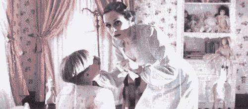 a woman in a white dress is standing next to a child .