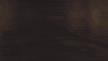 a blurry picture of a man standing in front of a wooden table .