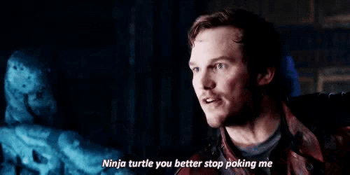a man in a red leather jacket is talking to a statue of a turtle .