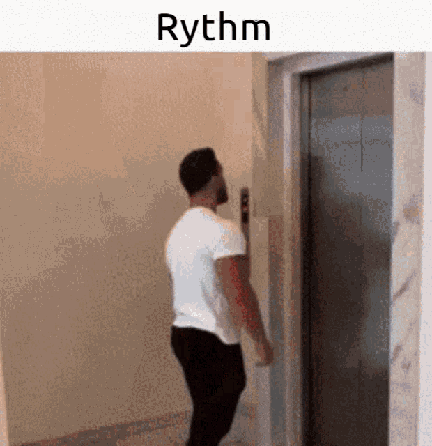 a man is standing in front of an elevator with the word rhythm written on the bottom .