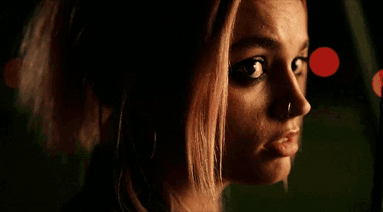 a woman with pink hair has a nose ring