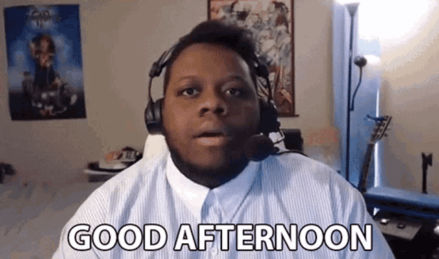 a man wearing headphones and a microphone is saying good afternoon