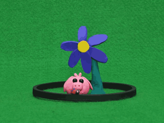 a pink pig with a flower in its mouth