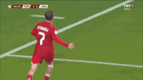 a group of men are hugging each other on a soccer field with a trt 1 logo in the corner