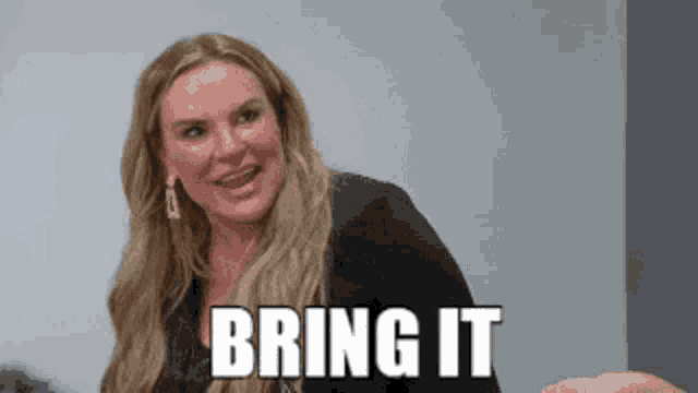 a woman with long blonde hair is smiling and says `` bring it '' .