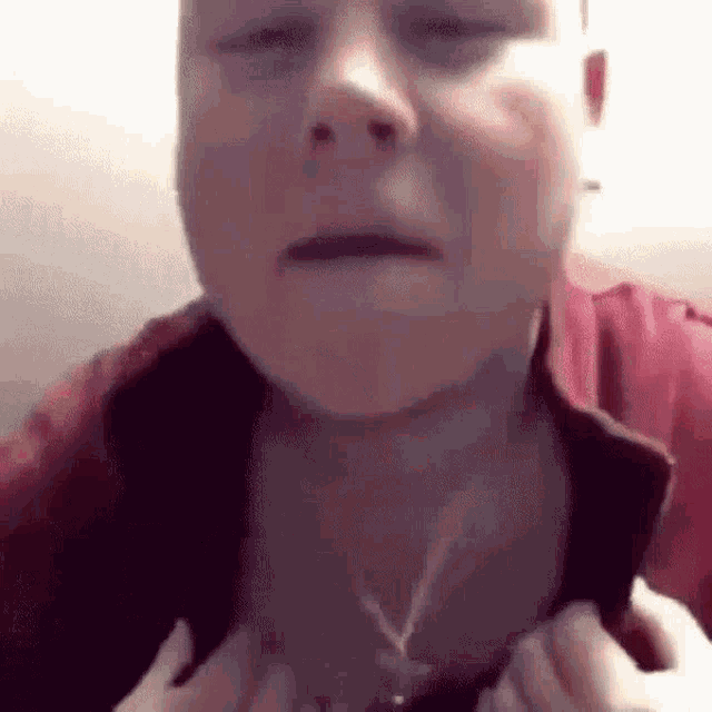 a close up of a man wearing a red shirt .