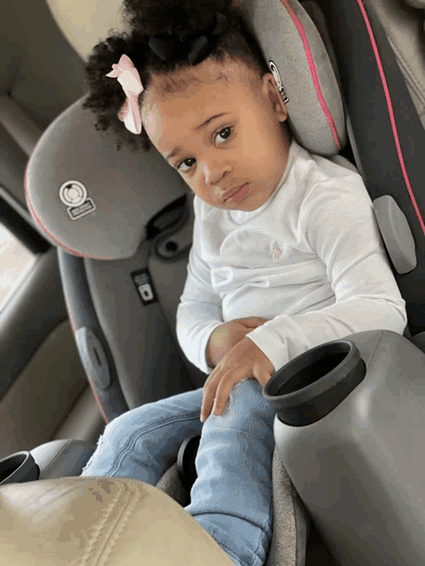 a little girl is sitting in a car seat that says safety 1