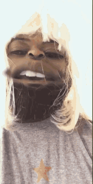 a man wearing a wig and a grey shirt with a gold star on it