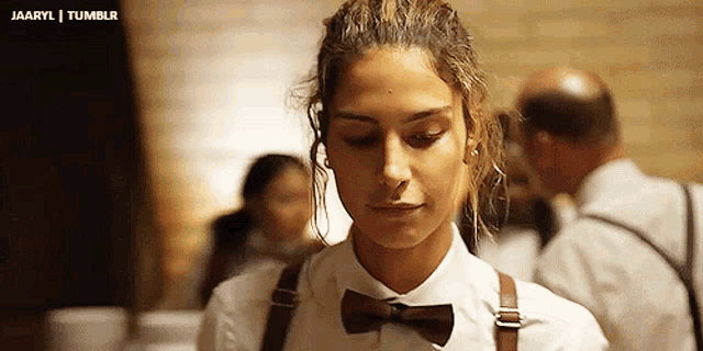 a woman is wearing a bow tie and suspenders .