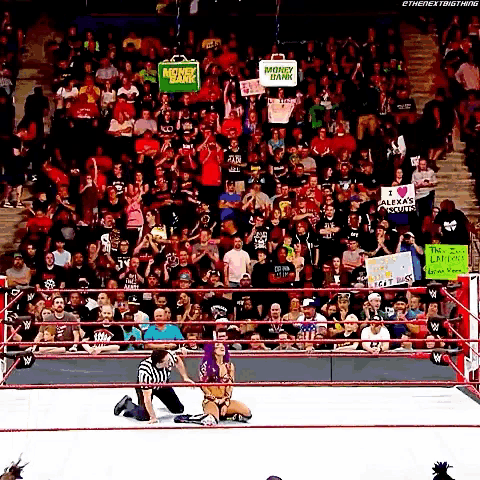 a crowd watching a wrestling match with a sign that says money bank on it