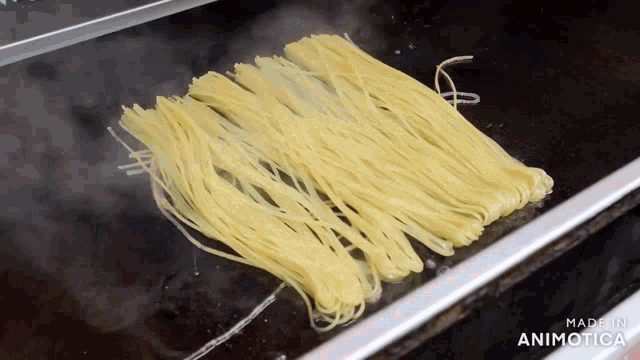 a bunch of noodles are being cooked on a stove and the words made in animotica are visible