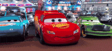 a bunch of cars are parked in front of a dinoco building