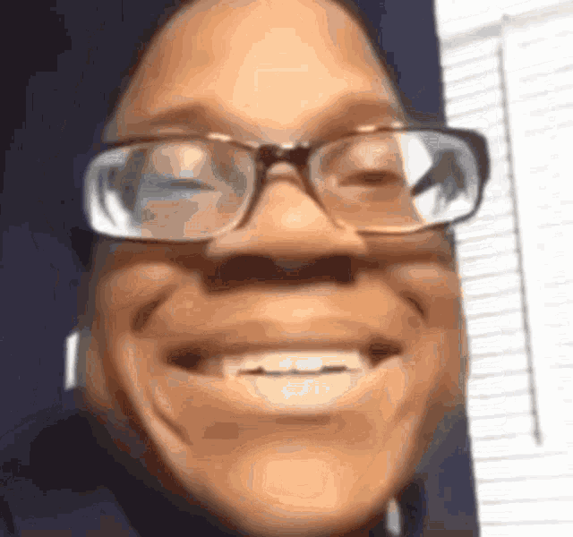 a close up of a person wearing glasses smiling .