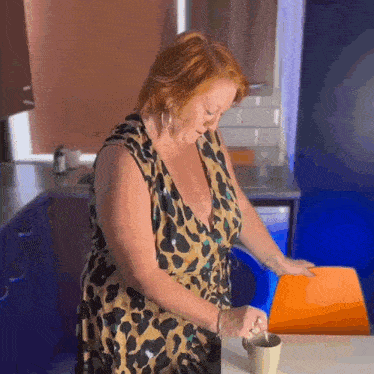 a woman in a leopard print dress is pouring something into a mug