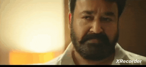 a man with a beard is wearing a white shirt .