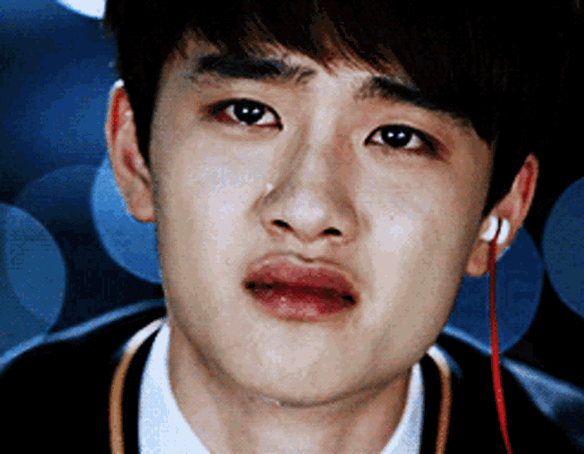 a close up of a young man 's face with a tear running down his face