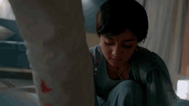 a woman in a blue dress is looking down