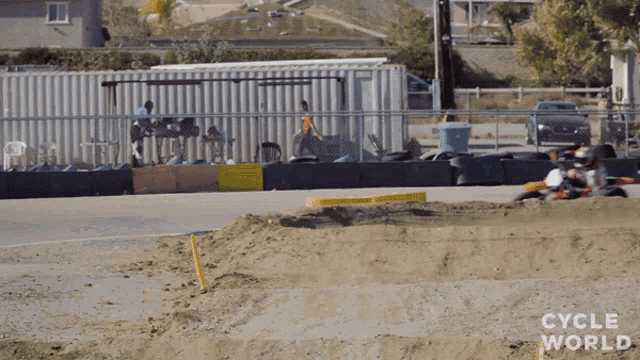 a motorcycle is going down a track with the words cycle world on the bottom right