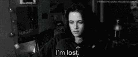 a black and white photo of a woman sitting at a table with the words `` i 'm lost '' .
