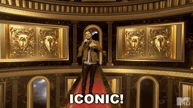 a man stands on a red carpet with the word iconic written on the bottom