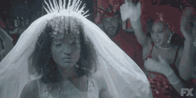 a woman in a wedding dress with a veil and a fx logo on the bottom