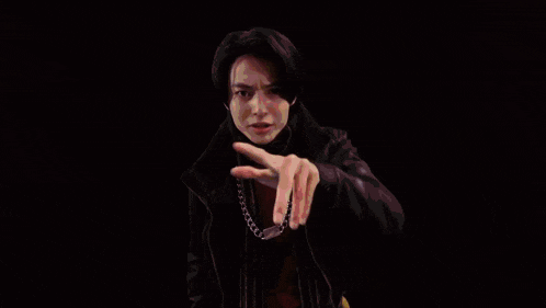 a man in a black jacket is giving the middle finger