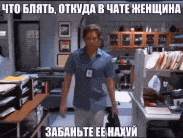 a man in a blue shirt is walking through a cluttered office with a caption in a foreign language