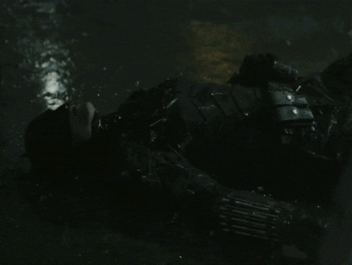 a person is laying in a dark room with a few pieces of metal visible