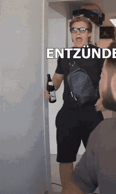 a man holding a bottle of beer with entzünde written on the bottom