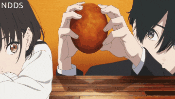 a boy and a girl are looking at a food item with ndds on the bottom right