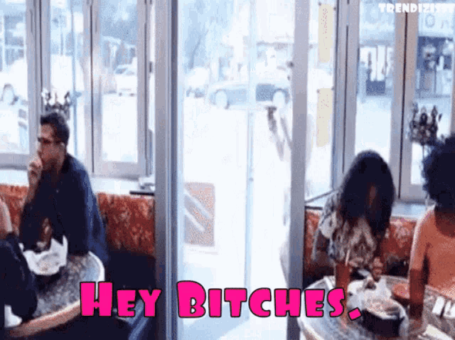 a group of people sitting at tables with the words hey bitches written on the bottom