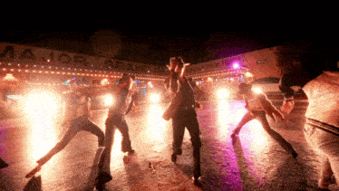 a group of people are dancing in front of a major grand building