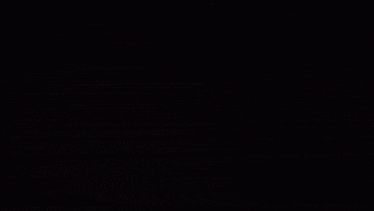 a person is writing on a piece of paper with a pen in the dark