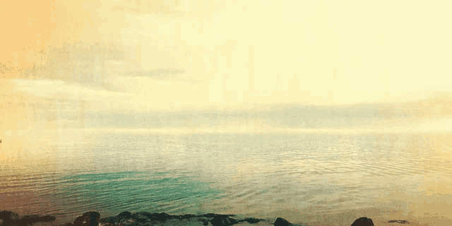 a painting of a large body of water with a yellow sky in the background