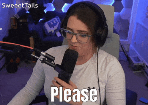 a woman wearing headphones and glasses is holding a microphone and saying please