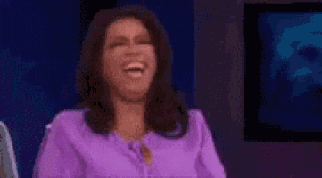 a woman is sitting on a stage with her hands in the air .