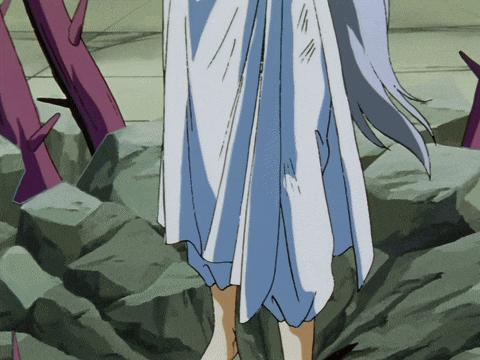 a woman in a white dress is standing on a rocky surface
