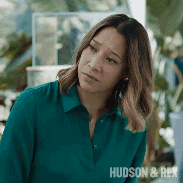 a woman in a green shirt with the words hudson & rex written on the bottom