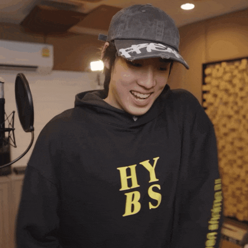a person wearing a hat and a hoodie that says hy bs on it