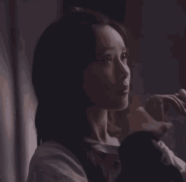 a close up of a woman 's face looking out a window .