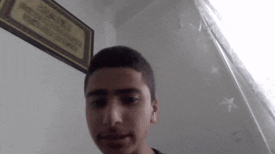 a young man is standing in front of a wall with a framed picture on it