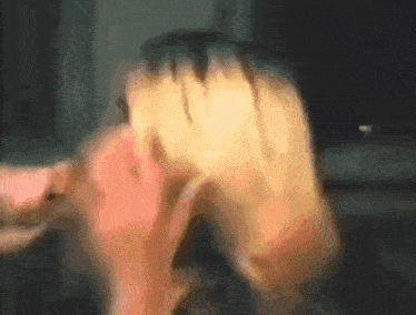 a blurry picture of a person 's face with their hands on it