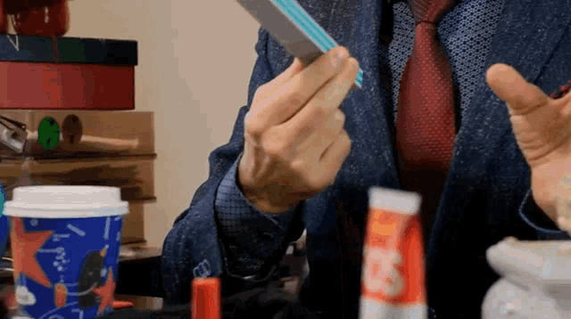 a man in a suit and tie holds a piece of paper