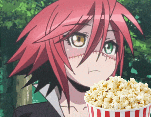 a girl with red hair is standing next to a striped bucket of popcorn